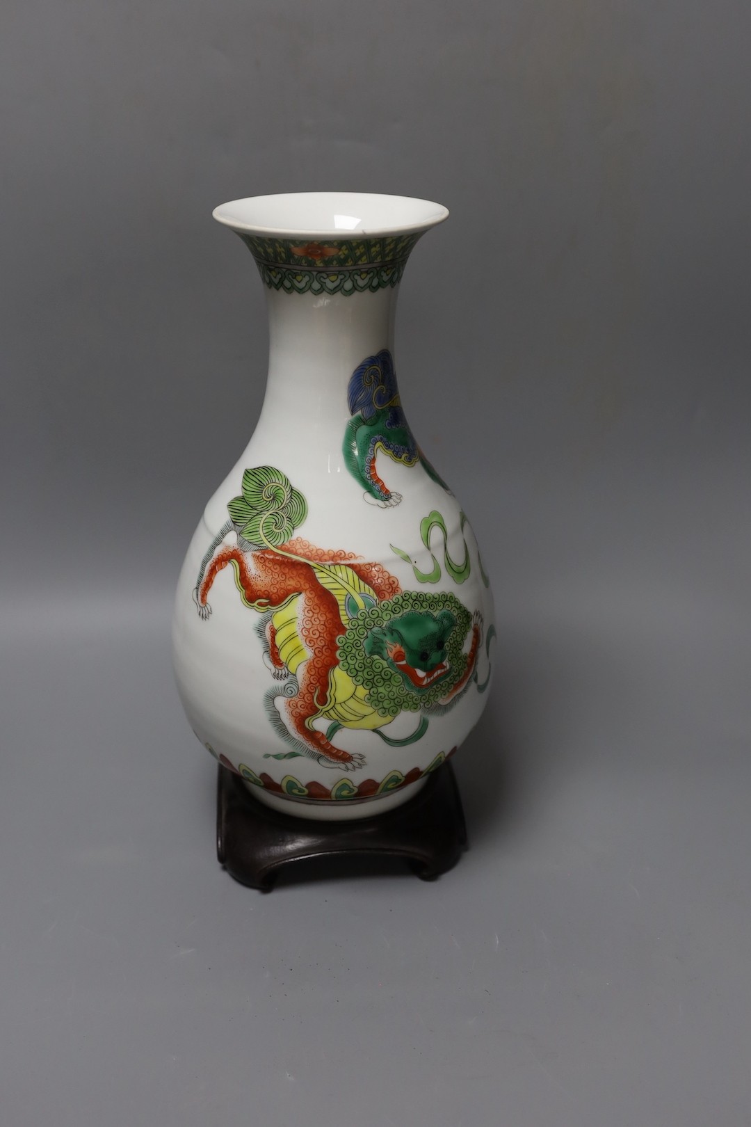 A Chinese famille verte pear shaped ‘Buddhist lion’ vase, on stand, 32 cms high not including stand.
